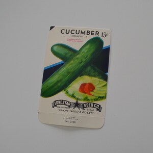 May include: Vintage seed packet for "Cucumber Straight-8" featuring a green cucumber illustration. The packet includes text for "Lone Star Seed Co. Texas" and the price of 15 cents. The packet is cream-colored with blue and black accents.