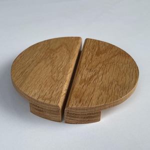 Può includere: Due tiretti per mobili in legno a forma di semicerchio, in legno marrone chiaro.