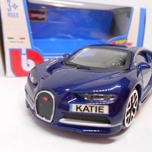 May include: A blue toy car with a personalised number plate that reads "KATIE". The car is a detailed model of a Bugatti Chiron.