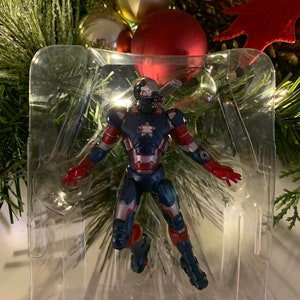 May include: A red, white and blue Iron Man Christmas ornament. The ornament is in clear plastic packaging.