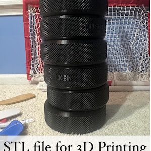May include: A vertical stack of six black, cylindrical, 3D-printed containers with a textured, diamond-patterned exterior. The middle container features the embossed text "LIPSTICK BIN". The stack is presented as an STL file for 3D printing.