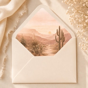 Pu&ograve; includere: Una busta aperta, color crema, rivela un paesaggio ad acquerello di una scena desertica. L'opera presenta un tramonto, montagne, cactus e piante del deserto in tonalit&agrave; marroni, beige e pesca. La busta &egrave; su uno sfondo neutro.