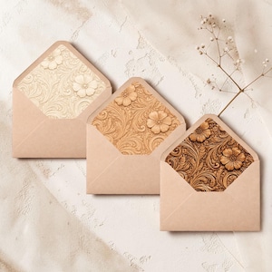 May include: Three open envelopes with light brown paper exteriors and interior liners featuring embossed floral and scroll patterns in varying shades of cream, tan, and dark brown, arranged in a diagonal line from top left to bottom right.