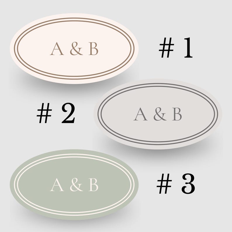 以下が含まれることがあります： 「A & B」の文字が入った3つの楕円形のステッカー。ステッカーはベージュ、グレー、グリーンの色合いで、それぞれ二重の縁取りがされています。各ステッカーの横には数字の1、2、3が印刷されています。