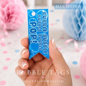 May include: A blue bubble tag with the words "POP!" and "BUBBLE BUBBLE BUBBLE" printed on it. The tag is held in a hand, with the words "BUBBLE TAGS" and "DIGITAL DOWNLOAD" at the bottom. The words "BLUE EDITION" are at the top.