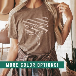 May include: A brown t-shirt with a white geometric design. The design features a series of lines and circles, creating a modern and abstract look. The shirt is made of a soft, comfortable material and is perfect for everyday wear.