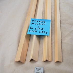 May include: Four unfinished wooden corner molding pieces and ridge caps. A blue sticky note reads "CORNER MOLDING 3 1/2 SCALE RIDGE CAPS". A small square reads "ONE INCH SQUARE 25mm".