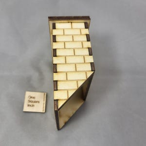 Puede incluir: Una pared de ladrillos de madera en miniatura con bordes marrones oscuros. La pared está en ángulo y tiene un pequeño cuadrado de madera con el texto "One Square Inch". El patrón de ladrillos es marrón claro.