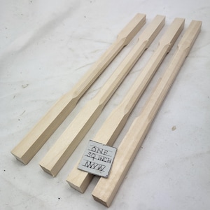 May include: Four unfinished wooden dowels with a square cross-section and a slight taper. The dowels are approximately 1 inch square and 12 inches long. A handwritten note reads "ONE SQ INCH WWW".