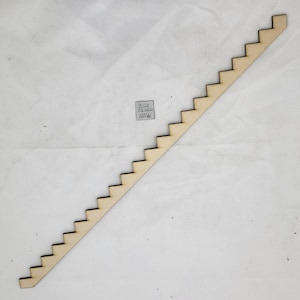 Op de afbeelding: Een houten trap met 12 treden, elk 2,5 cm breed. De trap is gemaakt van onbehandeld hout en is perfect om details toe te voegen aan een miniatuur poppenhuis of model.