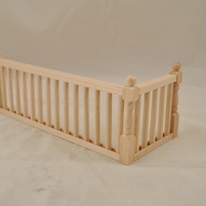 May include: A wooden railing with a corner design. The railing is made of natural wood and has a light brown color.
