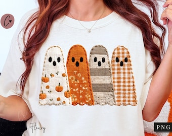 Pode incluir: Camiseta creme com quatro figuras de fantasmas aplicadas. Cada fantasma tem um padrão diferente: abóboras, floral, listras e xadrez. Os fantasmas têm olhos e bocas pretas. A camiseta é um design com tema de outono.