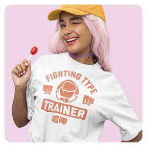 May include: White t-shirt with a peach-colored graphic that says "Fighting Type Trainer" with a boxing glove icon. The text "喧嘩" is below the graphic.