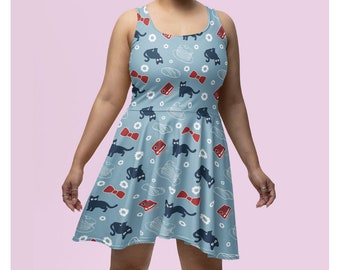 May include: A light blue skater dress featuring a repeating pattern of black cats, red bow ties, books, and white cloud and flower designs. The sleeveless dress has a scoop neckline and a flared skirt.