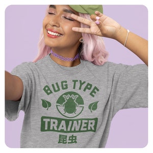 May include: A gray t-shirt with a green graphic that says "Bug Type Trainer" with a bug illustration and the Japanese word for bug in green text.
