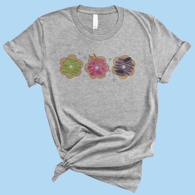 May include: A heather grey t-shirt with a design of three colorful donuts with different toppings.
