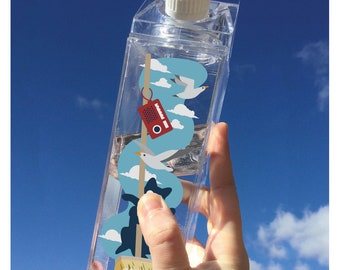 May include: A clear plastic water bottle with a white lid and a design of seagulls flying over clouds. The design also includes a red and white radio and a broom.