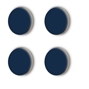 Puede incluir: Cuatro botones redondos de color azul oscuro con un borde ligeramente elevado.