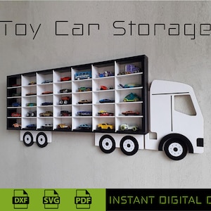 Puede incluir: Un estante de almacenamiento de coches de juguete blanco y negro con forma de camión de plataforma. El estante tiene 24 compartimentos para guardar coches de juguete. El texto "Toy Car Storage" está en la parte superior de la imagen.