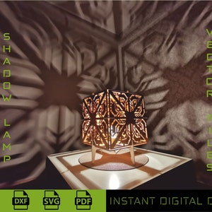 Könnte beinhalten: Eine Holzlampe mit geometrischem Design wirft komplizierte Schatten an die Wand. Die Lampe steht auf einem Holztisch und hat eine Glühbirne im Inneren. Der Text "SHADOW LAMP" und "VECTOR FILES" ist links und rechts im Bild zu sehen.  INSTANT DIGITAL DOWNLOAD steht am unteren Rand des Bildes.
