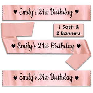 May include: Pink satin sashes with the text "Emily's 21st Birthday" and a heart on each side. The image shows three sashes, one of which is folded in half. The text "1 Sash & 2 Banners" is also included in the image.