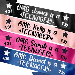 May include: Four satin sashes in different colours with the text "OMG [Name] is a TEENAGER!" and a star with the number 13 on each sash. The sashes are pink, blue, black, and hot pink.