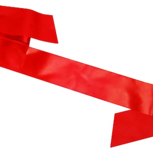 May include: A bright red satin ribbon, folded in half and tied in a knot. The ribbon is long and flowing, with a smooth, silky texture.