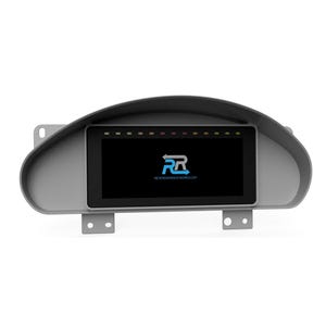 May include: A gray dashboard gauge cluster with a black screen displaying the logo of Reversion Race Works. The screen is surrounded by a gray bezel with indicator lights at the top. The logo features the letters "RR" in a stylized design.