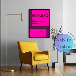 May include: A black framed poster with a pink background and the text "FLEABAG by PHOEBE WALLER-BRIDGE" in black. The poster is hanging on a white wall in a living room setting.