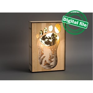May include: A wooden box with a cutout of a Bigfoot footprint. The footprint is illuminated from behind, creating a silhouette of Bigfoot walking through a forest.