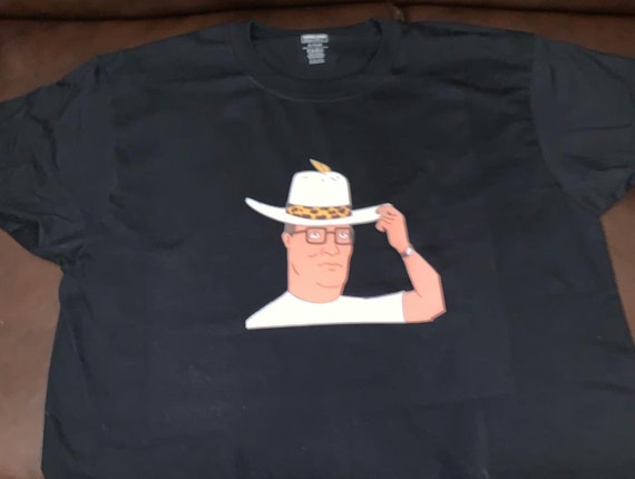 Hank Hill Pimp Hat Premium T-Shirt en Tailles Homme S-3XL en Blanc ou Noir  Imprimé sur le t-shirt de la marque Kirkland -  Canada