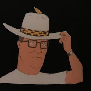 Hank Hill Pimp Hat Premium T-Shirt in Mens Sizes S-3XL in White or Black! Printed on Kirkland Brand T-Shirt!