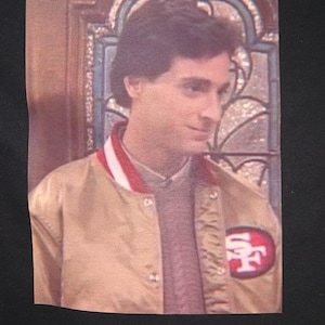 Bob Saget “Danny Tanner” Gold 49er Jacket Premium T-Shirt in Mens sizes S-3XL in white or black! Printed on Kirkland brand T-Shirts!