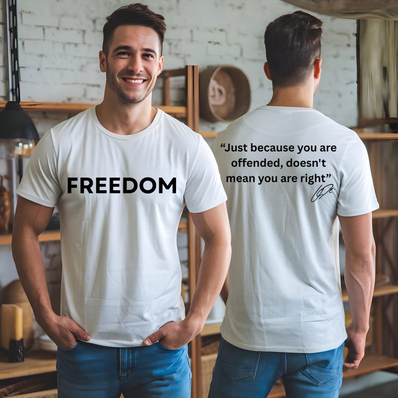 May include: White t-shirt with the word "FREEDOM" printed in black on the front. The back of the shirt features the quote, "Just because you are offended, doesn't mean you are right."