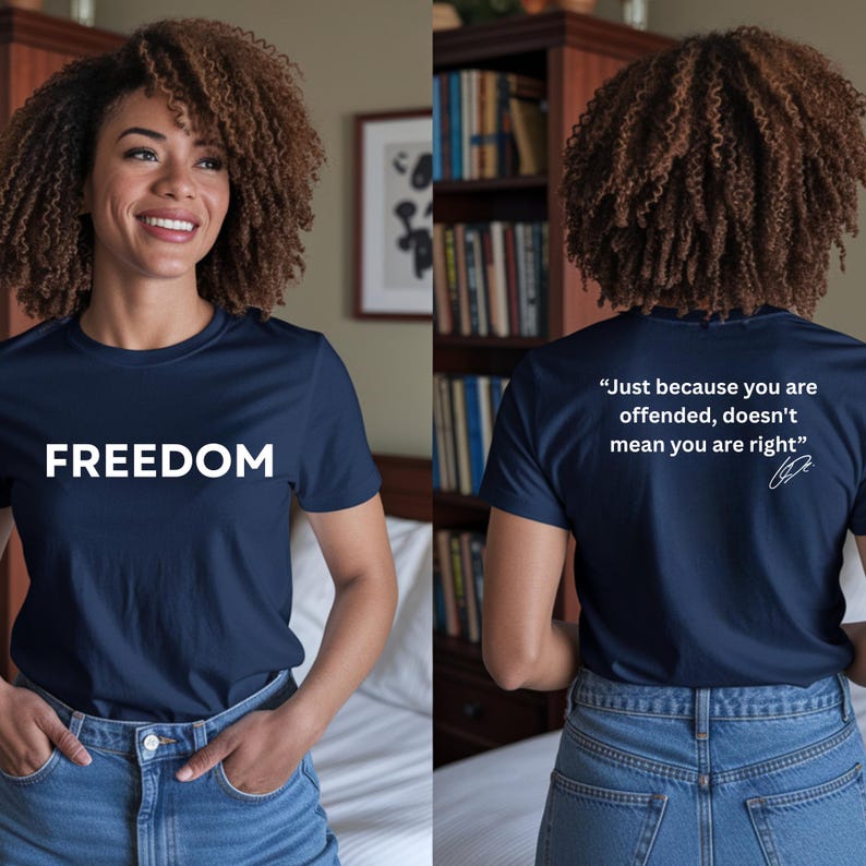 May include: Navy blue t-shirt with the word "FREEDOM" in white block letters on the front. The back of the shirt has the quote, "Just because you are offended, doesn't mean you are right."