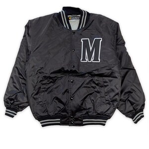 May include: Black satin varsity jacket with a large white "M" on the front. The jacket has a grey and white striped collar and cuffs.