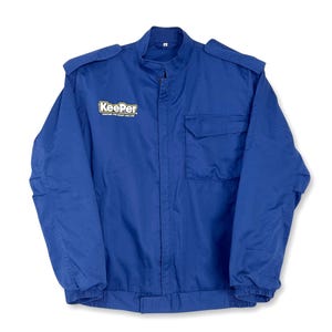 May include: A blue work jacket with a zipper closure and a Keeper logo on the front. The logo is yellow with black lettering and says "Keeper" with the tagline "Creating the Smart Car Life".