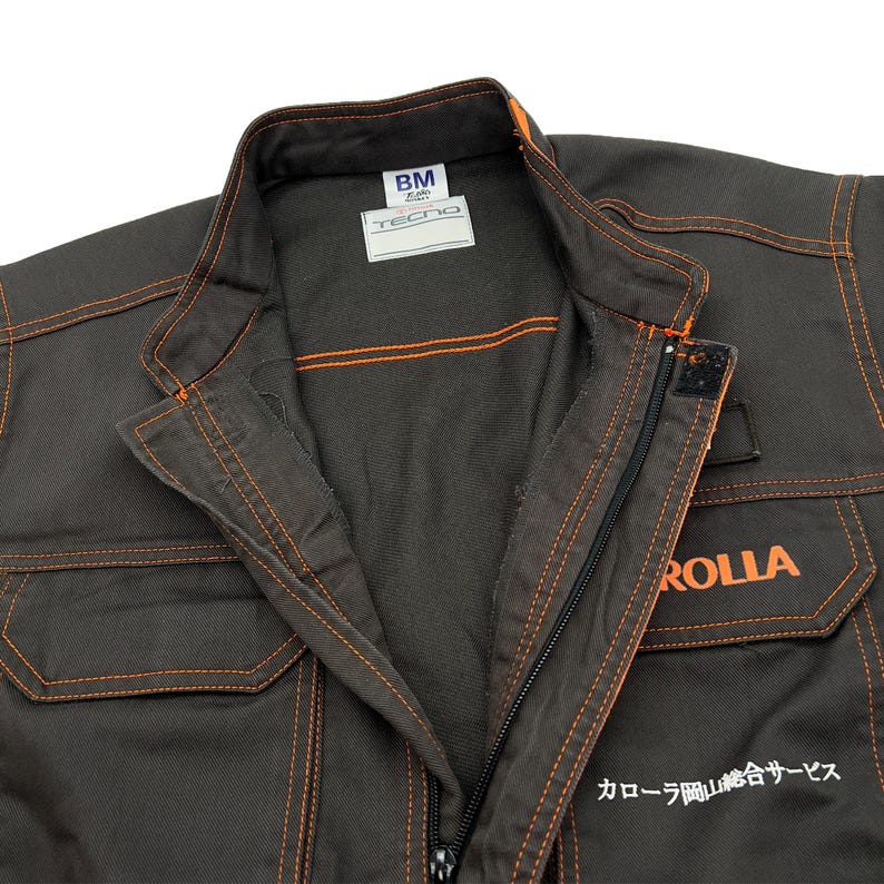 Very rare straight from Japan JDM TOYOTA トヨタ Corporate Tecno mechanic jumpsuit - coverall suite; A true gem for automotive enthusiasts seeking a unique piece of automotive history. This tsunagi is unavailable in the States, making it a rare find that sets you apart from the crowd.