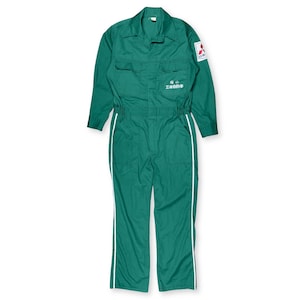 May include: Green work jumpsuit with white stripes down the legs. The jumpsuit has a collared neckline, multiple pockets, and a patch on the upper arm. Text is visible on the chest area. The jumpsuit is made of a durable material.