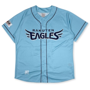 Puede incluir: Una camiseta de béisbol azul claro con ribetes azul marino y las palabras "Rakuten Eagles" en un logotipo blanco y azul marino en la parte delantera. La camiseta tiene un frente abotonado y un pequeño logotipo en la manga izquierda.