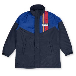 May include: A navy blue and royal blue winter jacket with a high collar. The jacket features a vertical stripe of red, orange, and yellow, and a white rectangular patch with the word "ENEOS".