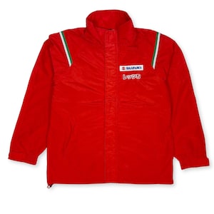 May include: A bright red jacket with a high collar and a zipper closure. The jacket features a Suzuki logo and Japanese text on the chest. Green and white stripes accent the shoulders. A sporty, lightweight outerwear piece.