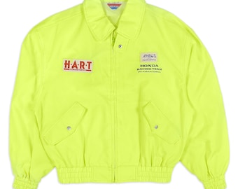 May include: Bright neon yellow jacket with a collar, zipper closure, and two front pockets. The jacket features the text "HART" and "HONDA RACING TEAM INTERNATIONAL" in red and white.