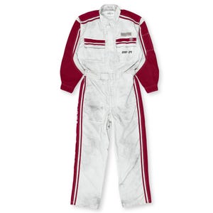 May include: White racing jumpsuit with red accents on the shoulders, sleeves, and sides. Features a Toyota logo and the number 981-39. The jumpsuit has multiple pockets and a front zipper.