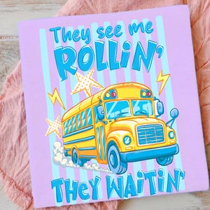 以下が含まれることがあります： 青い縦縞模様の薄紫色の背景に、青い文字で「They see me ROLLIN'、they waitin'」と書かれています。 黄色のスクールバスのグラフィックが中央にあり、星と稲妻のアクセントが付いています。