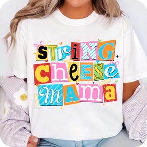 May include: White t-shirt with the words "String Cheese Mama" in colorful, block letter style. The text is arranged in three rows, with each word in a different color and font, creating a playful and eye-catching design.