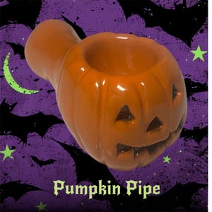 May include: Orange ceramic pumpkin pipe with carved facial features. The pipe has a bowl-shaped opening and a stem. The background is purple with black bat silhouettes, a green crescent moon, and green stars. The text "Pumpkin Pipe" is at the bottom.