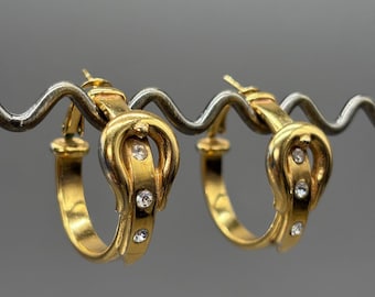Pendientes de aro vintage en tono dorado con diseño de hebilla de cinturón y cierre de pedrería estilo retro.