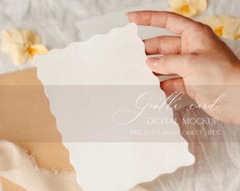 May include: A white card with a scalloped edge is held by a hand against a white fabric background. The card is blank and ready for your message. The text "Gentle card DIGITAL MOCKUP PSD with SMART OBJECT JPEG" is written below the card.