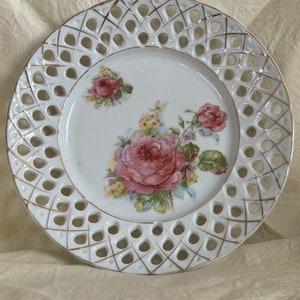 Antique decorative plate with gilded lattice edges with painted pink roses